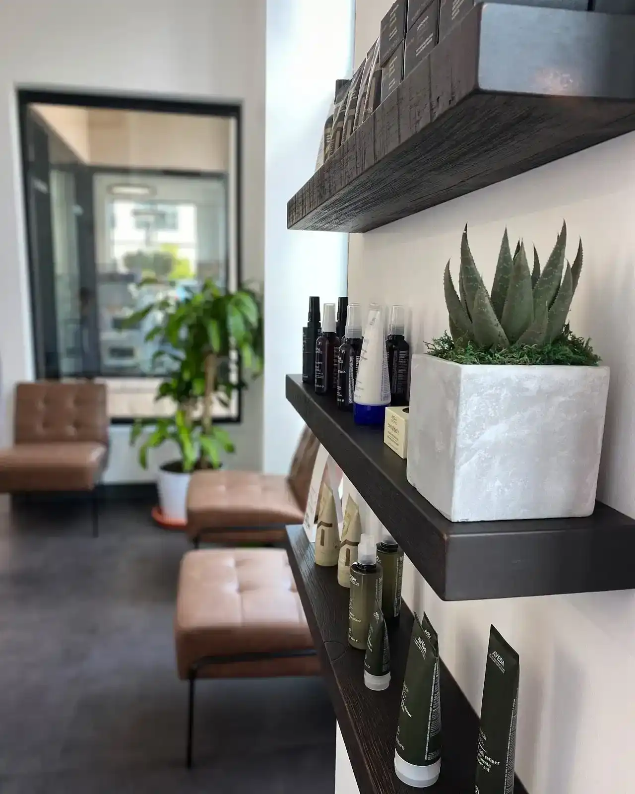 Modern lobby with skincare products on shelves and cozy seating.