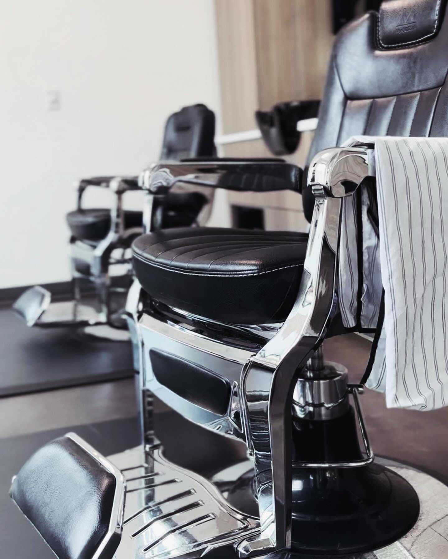 Barber chairs in a stylish salon, draped with a striped cloth.